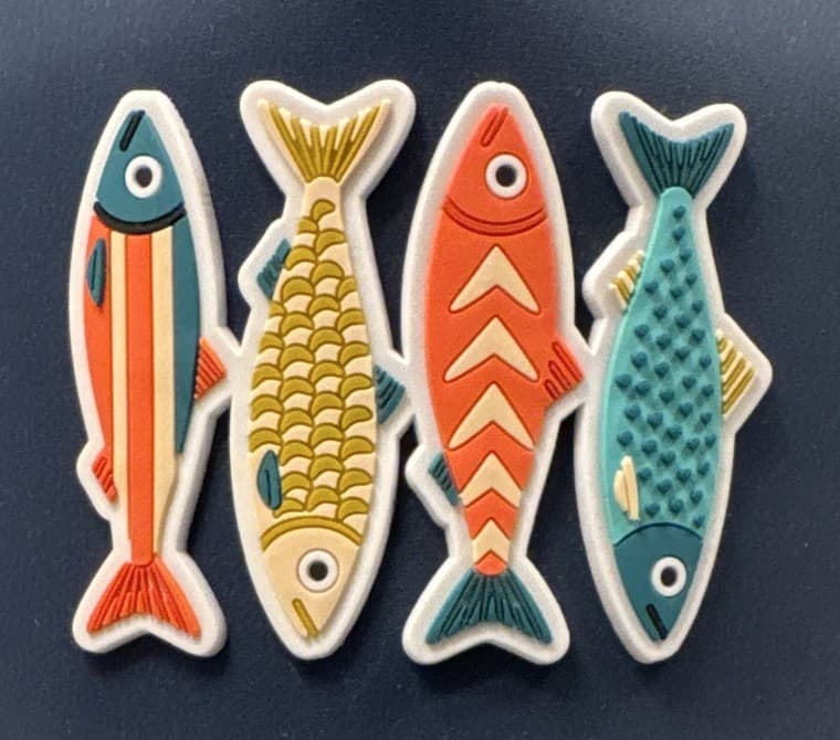 Raised four-fish patch in yellow, coral, teal, and green on navy cloth.